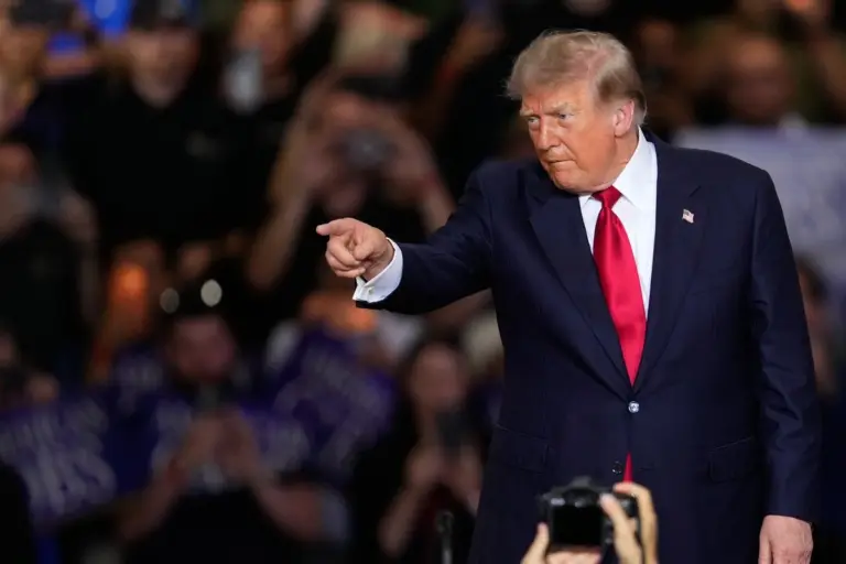 Donald Trump durante una conferencia mientras aparecen las banderas de Estados Unidos, México y Canadá al fondo.