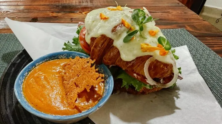 Desayunos en Guanajuato con café de olla, croissant relleno de pollo y panadería artesanal en una cafetería acogedora.